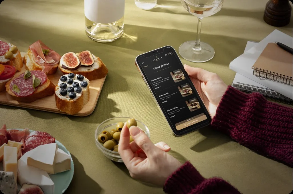 Telefon z otwartym menu QR na stole w restauracji